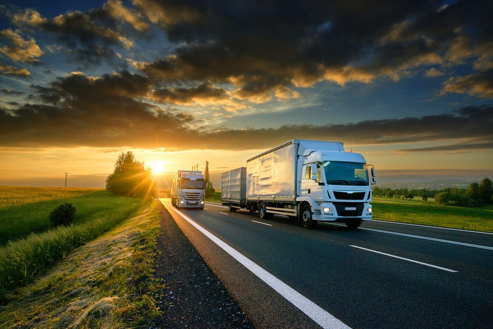 Sunset behind trucks on countryside road