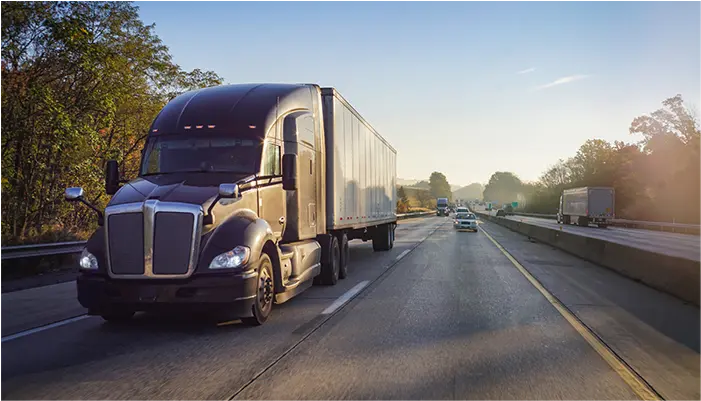 Semi-truck on the road at sunrise
