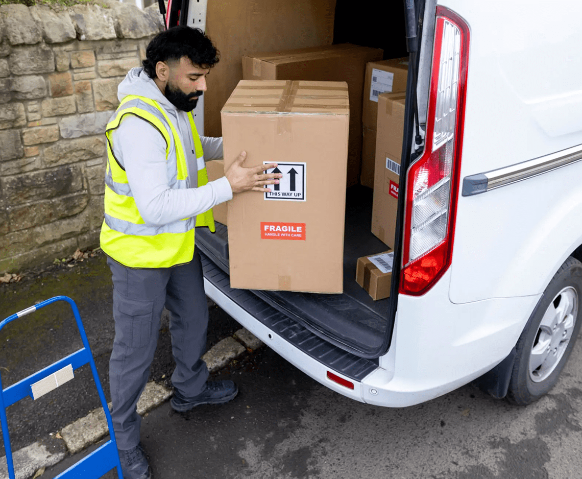 Man handling large package from vehicle
