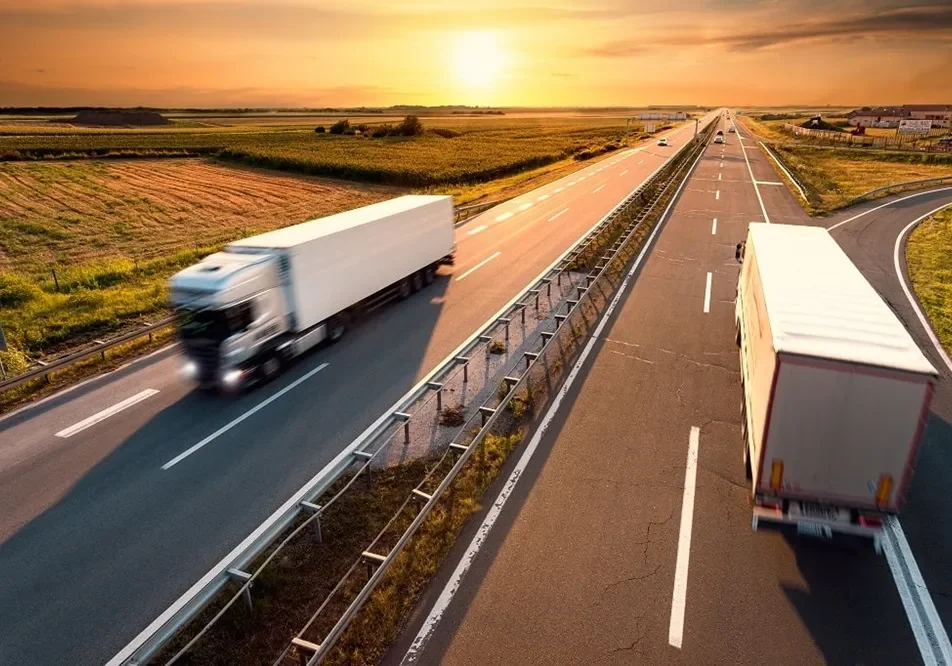 Two trucks driving on open road