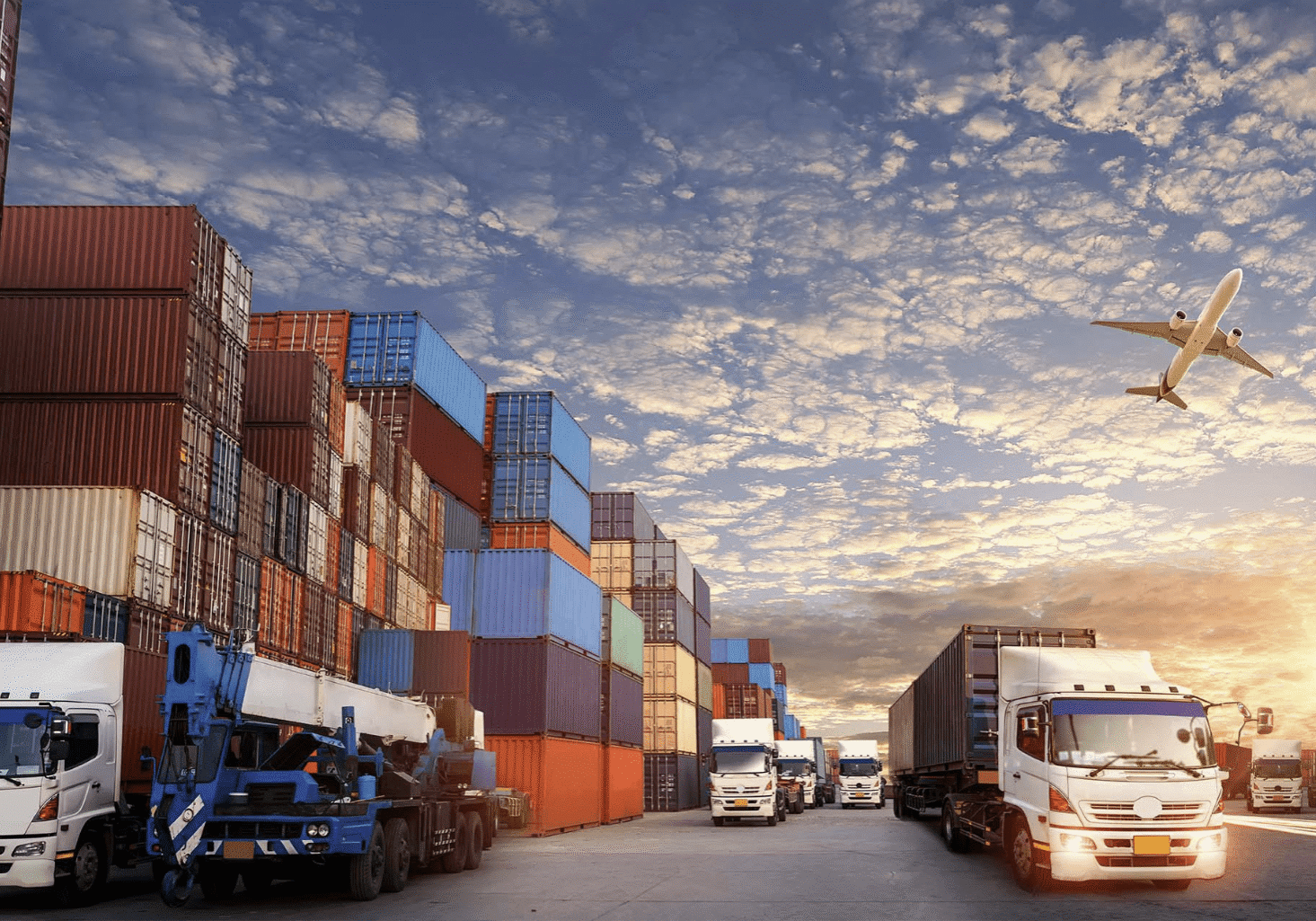 Shipping containers and trucks at sunset
