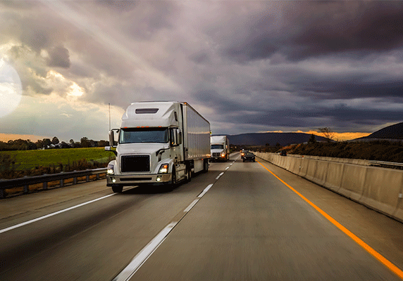 Freight semis under dramatic cloudy sky