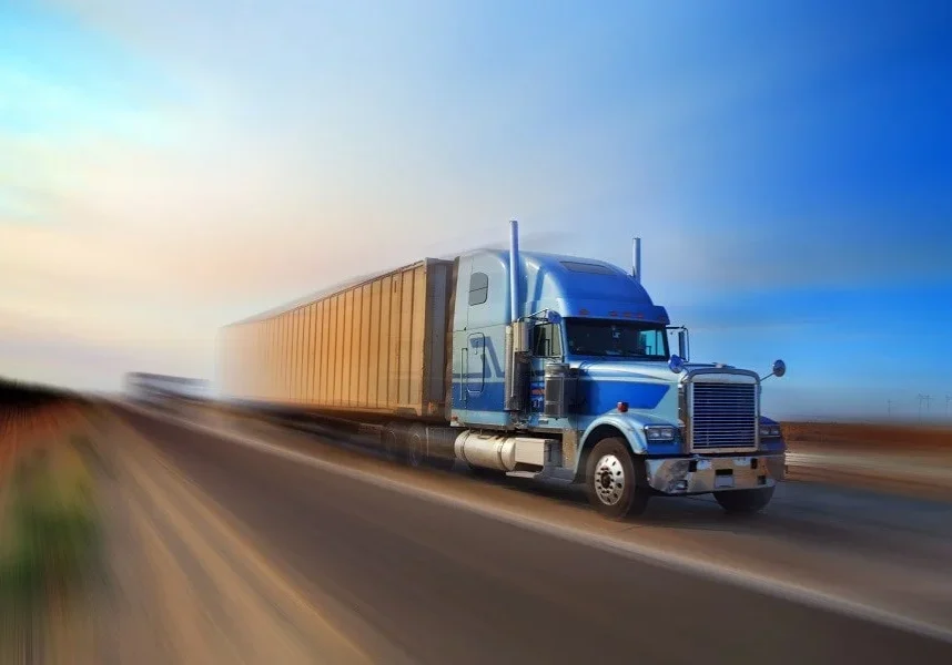 Long-haul truck driving at sunset